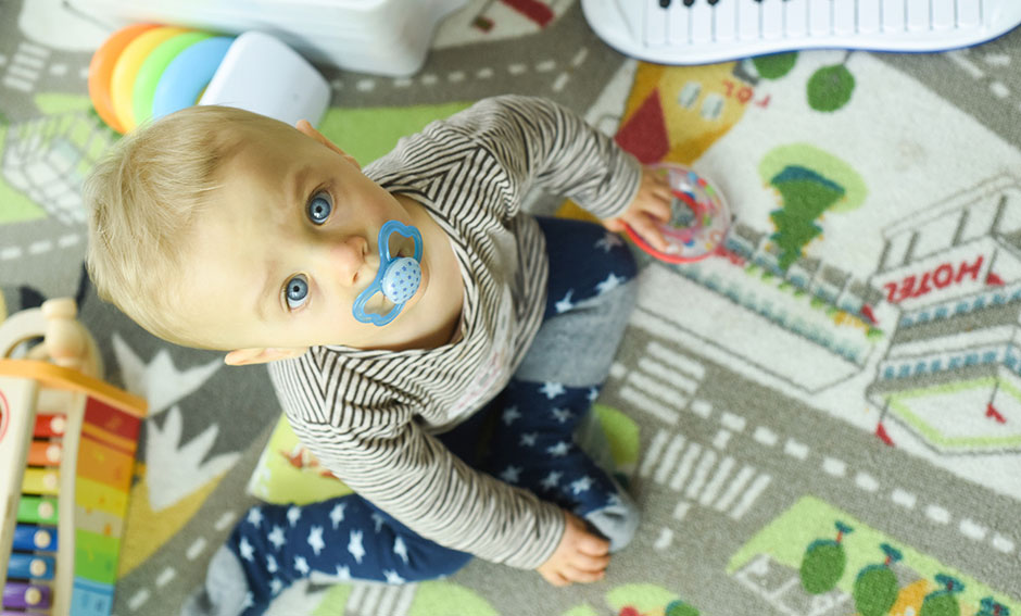 Babyfoto mit Blick nach oben auf Spielteppich