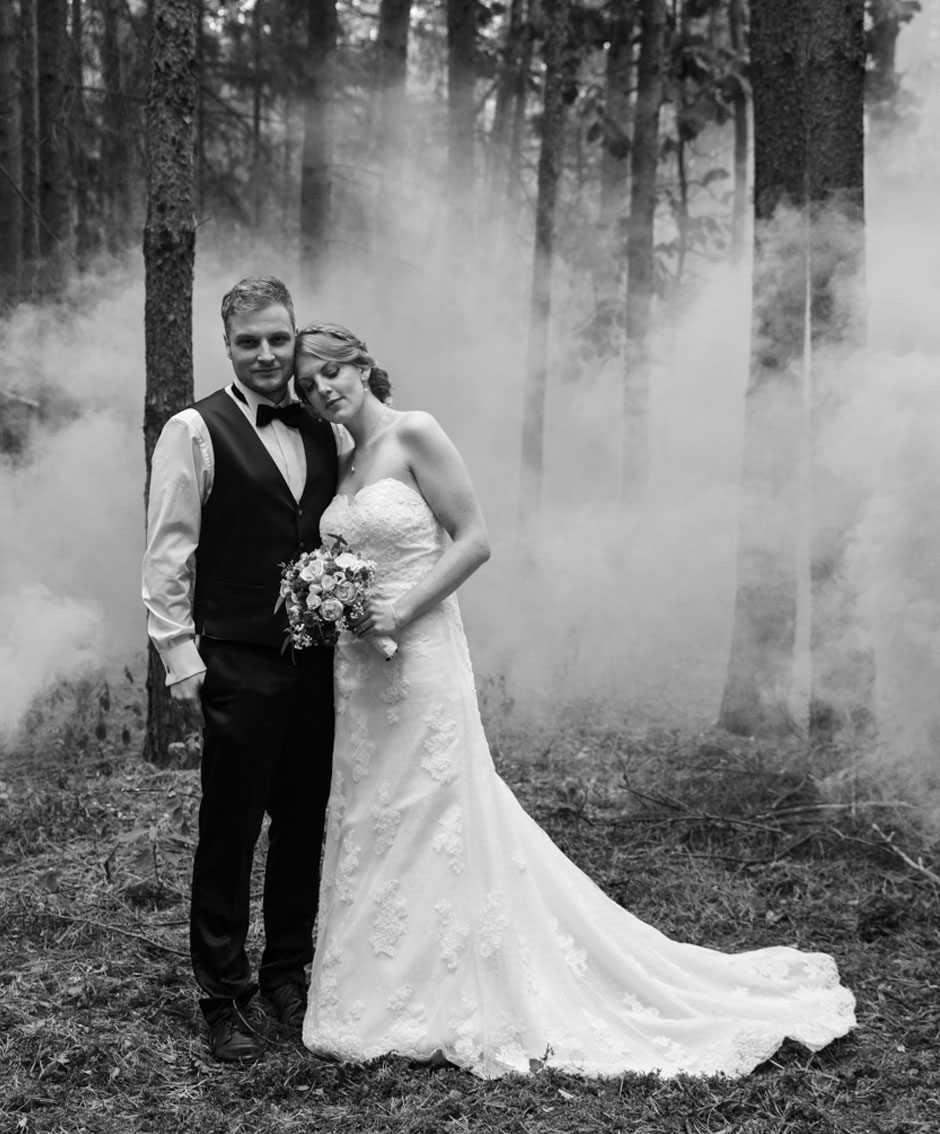 Hochzeitsfoto Brautpaar Shooting Mann und Frau stehen im Nebel im Wald Schwarzweiß