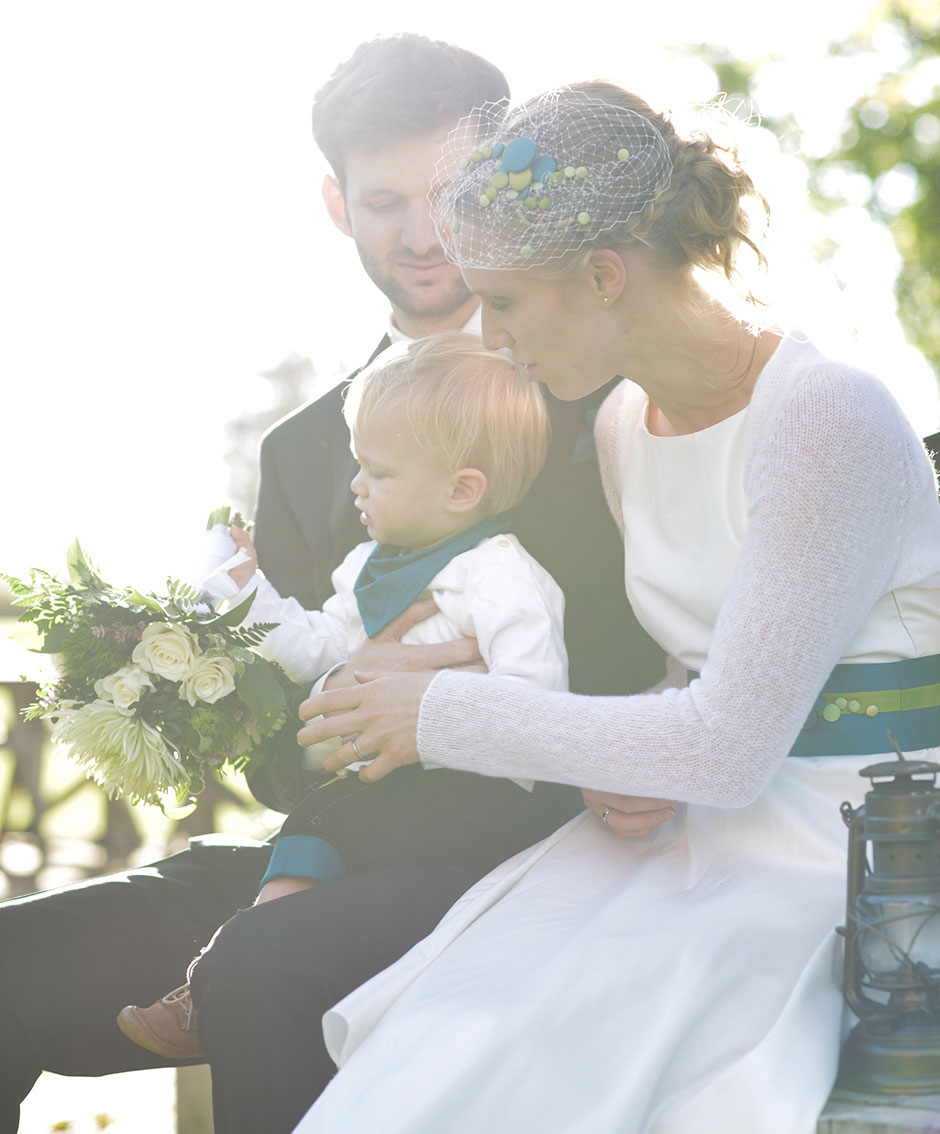 Hochzeitsfoto Hochzeitspaar gluecklich mit Kind in der Sonne